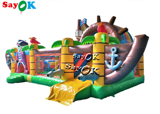 El pirata al aire libre salta el trampolín inflable del castillo con la diapositiva para los niños