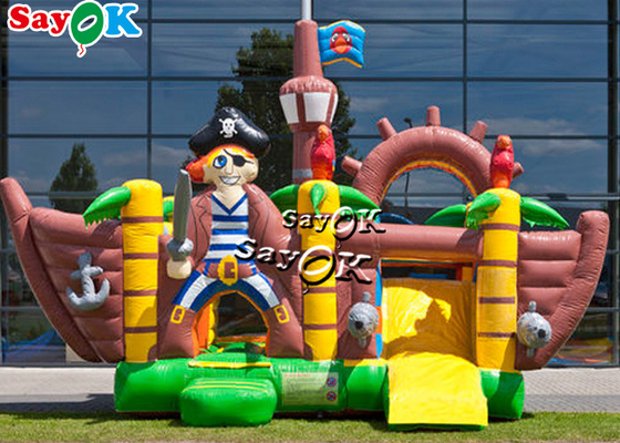 El pirata al aire libre salta el trampolín inflable del castillo con la diapositiva para los niños